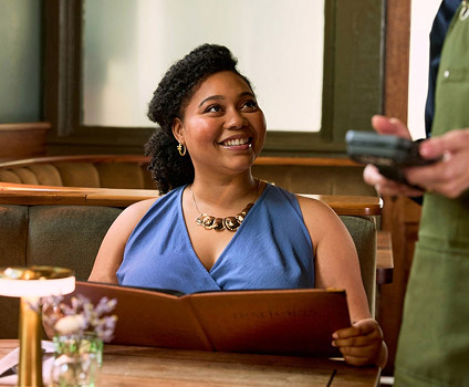 Woman smiling holding restaurant menu